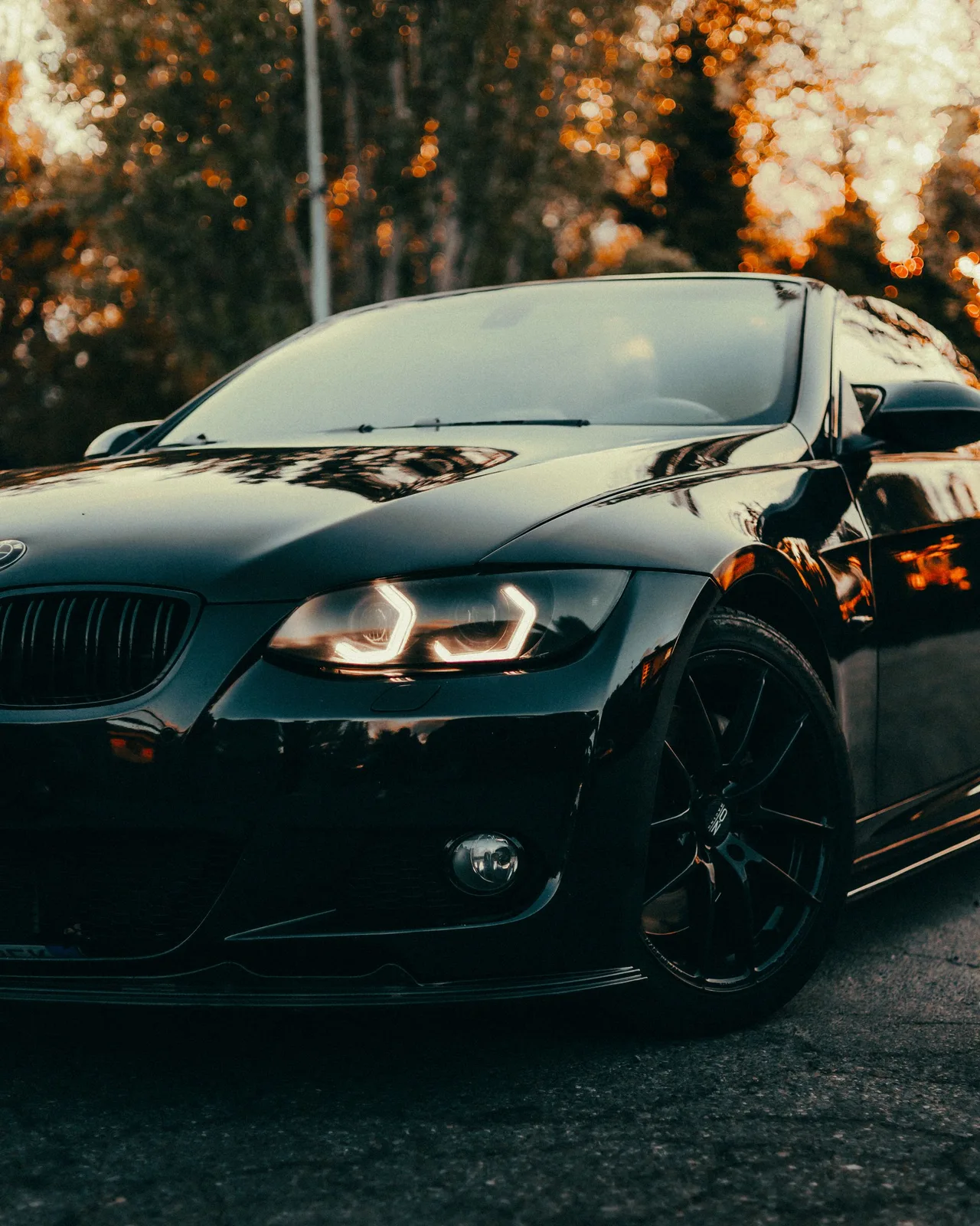 Sunset reflected in the glossy hood of a black car — illustrative stock photograph.